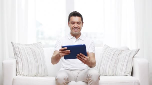 Uomo sorridente che lavora con tablet pc a casa — Video Stock
