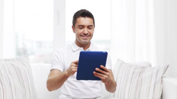 Homme souriant travaillant avec tablette pc à la maison — Video