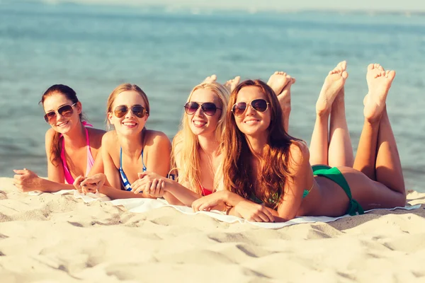 Grupo de mujeres sonrientes en gafas de sol en la playa —  Fotos de Stock