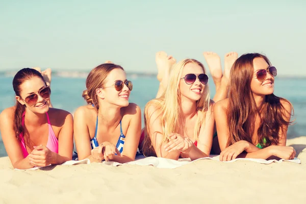 Grupo de mulheres sorridentes em óculos de sol na praia — Fotografia de Stock