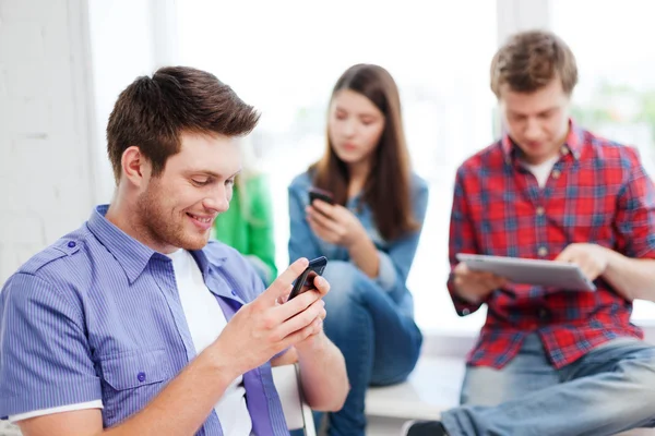 Studente in cerca di smartphone a scuola — Foto Stock