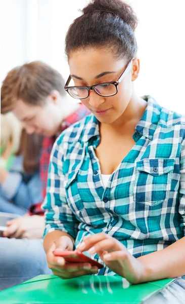 Menina estudante com smartphone na escola — Fotografia de Stock