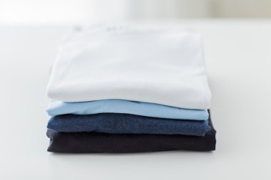 close up of ironed and folded t-shirts on table clipart