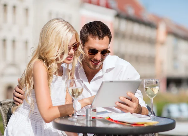 Paar kijken naar tablet pc in café — Stockfoto