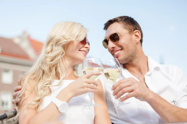 Pareja sonriente en gafas de sol bebiendo vino en la cafetería —  Fotos de Stock