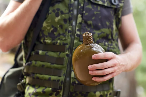 Close up of soldier with gun and flask in forest — Stock Photo, Image