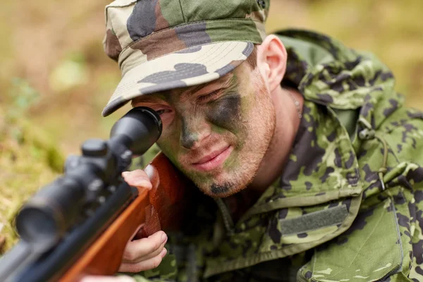 Soldier or hunter shooting with gun in forest — Stock Photo, Image