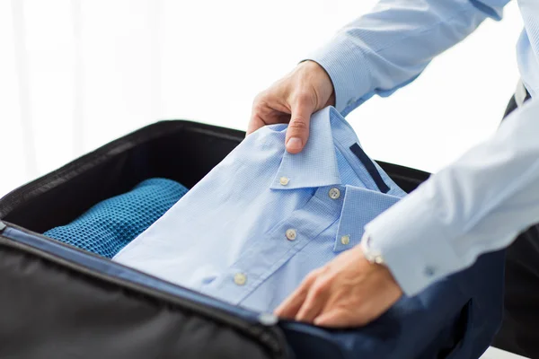 Uomo d'affari imballaggio vestiti in borsa da viaggio — Foto Stock