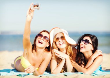 girls taking self photo on the beach clipart