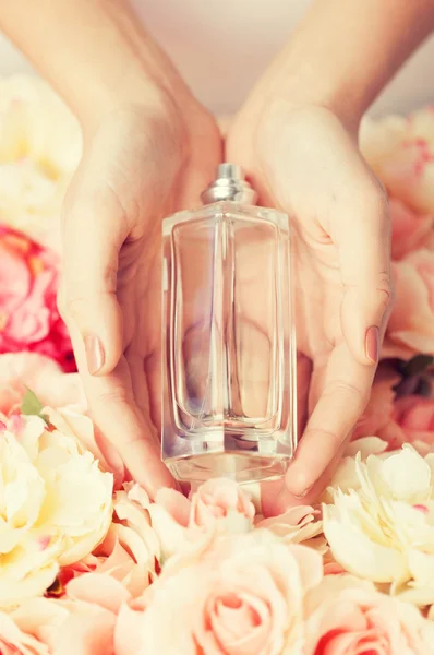Womans hands showing perfume — Stock Photo, Image