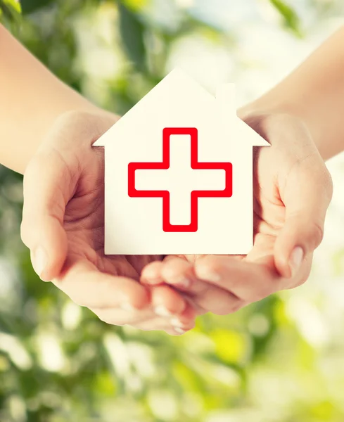 Hands holding paper house with red cross — Stock Photo, Image