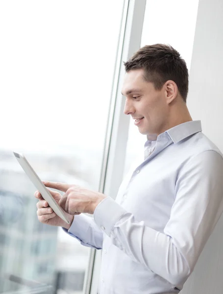 Smiling businessman with tablet pc in office — Stock Photo, Image