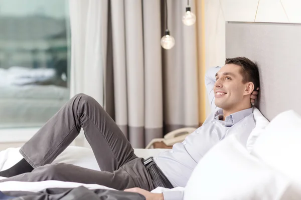 Feliz mujer de negocios acostada en la cama en la habitación de hotel —  Fotos de Stock