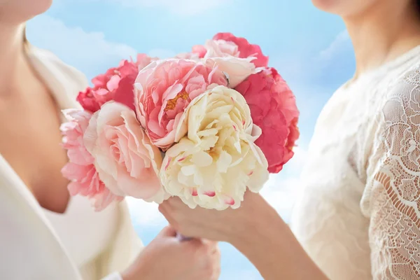 Close up of happy lesbian couple with flowers — Stock Photo, Image