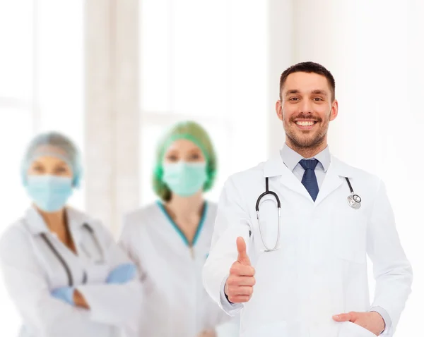 Usmívající se doktor s stetoskop ukazuje palec — Stock fotografie