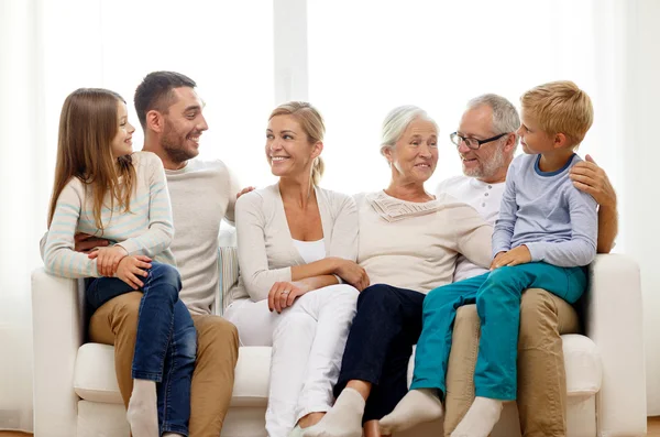 Happy family sitting on couch at home — Stock Photo, Image