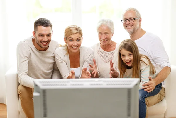 Família feliz assistindo TV em casa — Fotografia de Stock