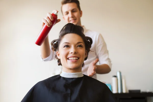 Mulher feliz com estilista fazendo penteado no salão — Fotografia de Stock