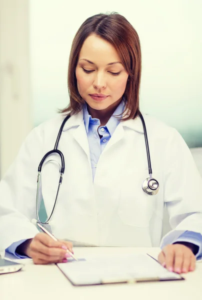 Busy doctor with laptop computer and clipboard — Stock Photo, Image