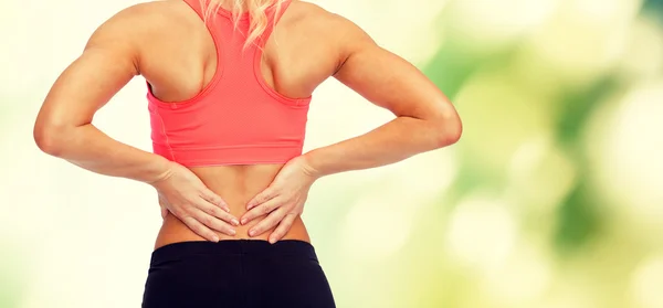 Close up of sporty woman touching her back Stock Photo