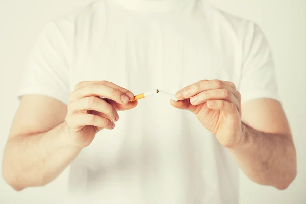 Hombre rompiendo el cigarrillo con las manos — Foto de Stock