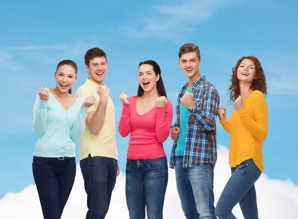 Grupp leende tonåringar visar triumf gest — Stockfoto