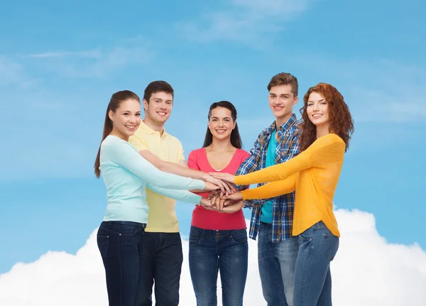 Lachende tieners met handen bovenop elkaar — Stockfoto