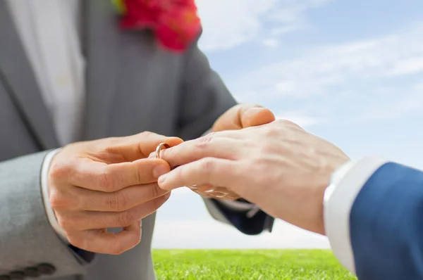 Close up de masculino gay casal mãos e anel de casamento — Fotografia de Stock