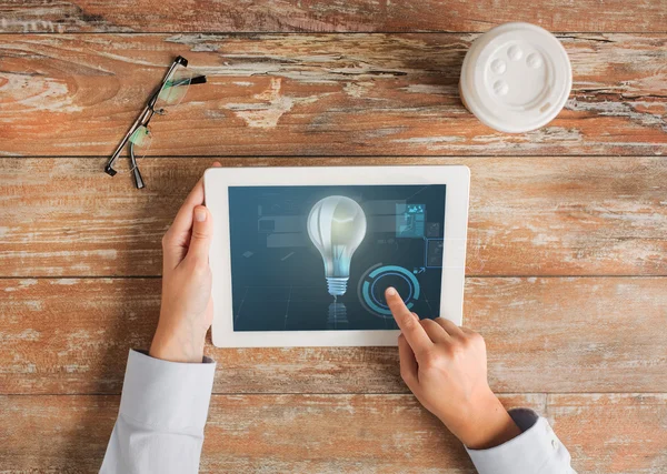 Primo piano delle mani con tablet pc e lampadina — Foto Stock