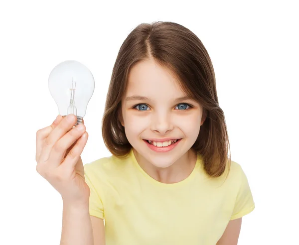 Улыбающаяся маленькая девочка держит лампочку — стоковое фото