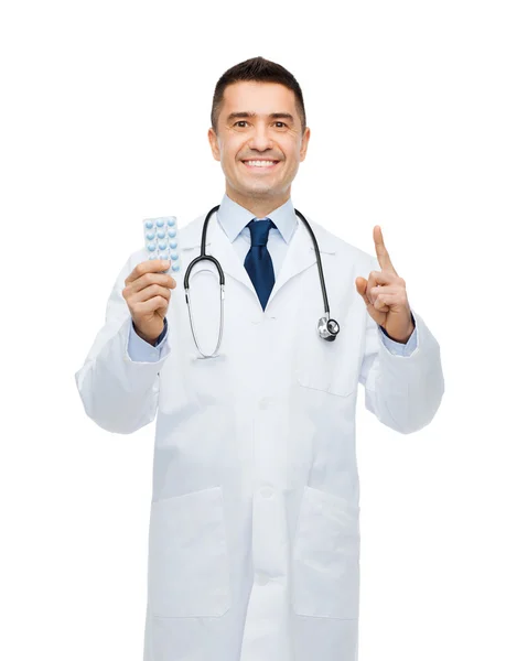 정제와 흰색 코트에 남성 의사 미소 — 스톡 사진