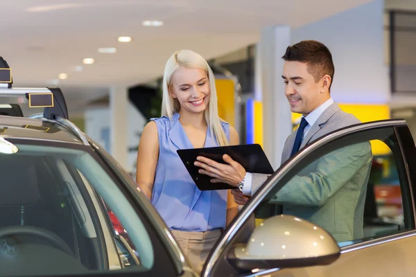 Donna felice con rivenditore di auto in salone o salone di auto — Foto Stock