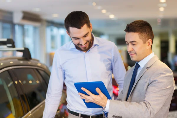 Happy man with car dealer in auto show or salon — Stock Photo, Image