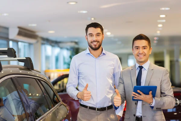 Hombre feliz mostrando pulgares hacia arriba en el auto show o salón —  Fotos de Stock