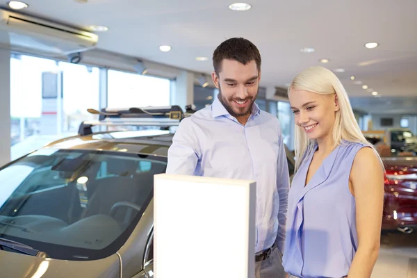 Feliz pareja comprando coche en auto show o salón — Foto de Stock