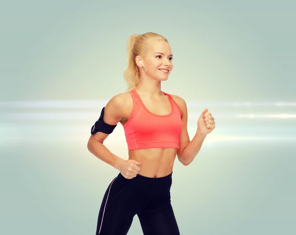 Mujer deportiva corriendo con smartphone y auriculares —  Fotos de Stock