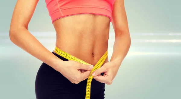 Close up of female hands measuring waist — Stock Photo, Image