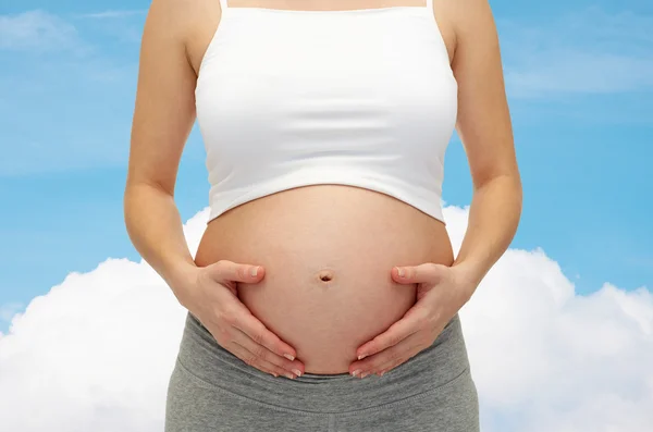 Close up of pregnant woman touching her bare tummy — Stock Photo, Image