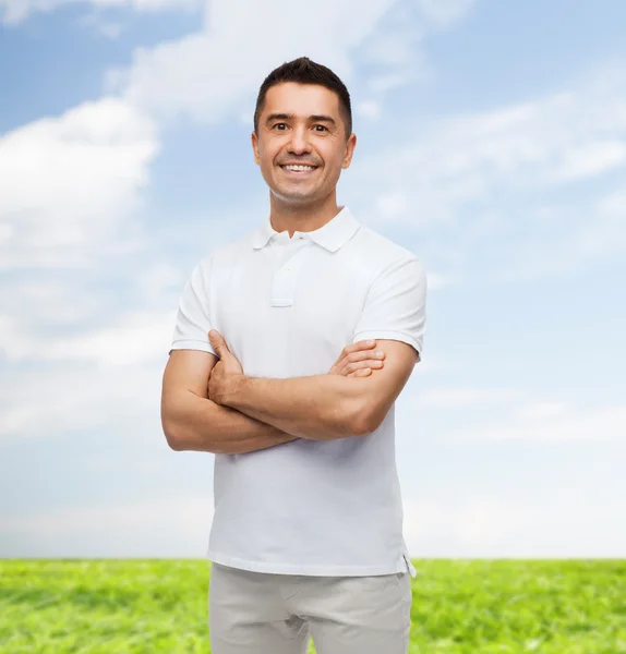 Hombre sonriente en camiseta blanca con brazos cruzados — Foto de Stock