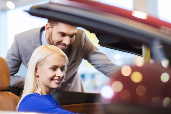 Happy couple buying car in auto show or salon — Stock Photo, Image