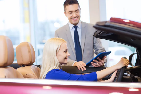 Femme heureuse avec concessionnaire automobile en salon ou salon de l'auto — Photo