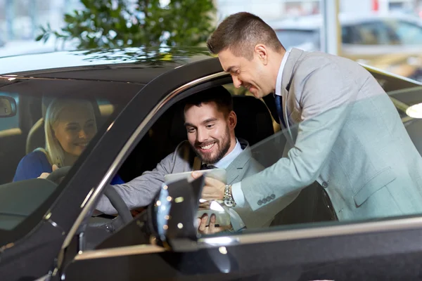 Otomobil Fuarı veya salon araba satıcısı ile mutlu çift — Stok fotoğraf
