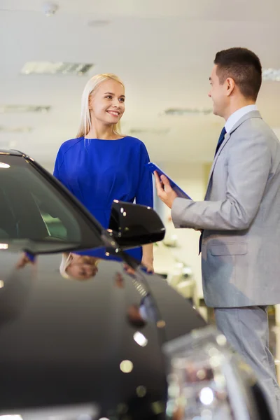 Donna felice con rivenditore di auto in salone o salone di auto — Foto Stock