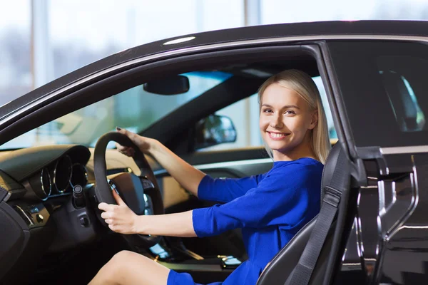 Glückliche Frau im Auto in Autoshow oder Salon — Stockfoto