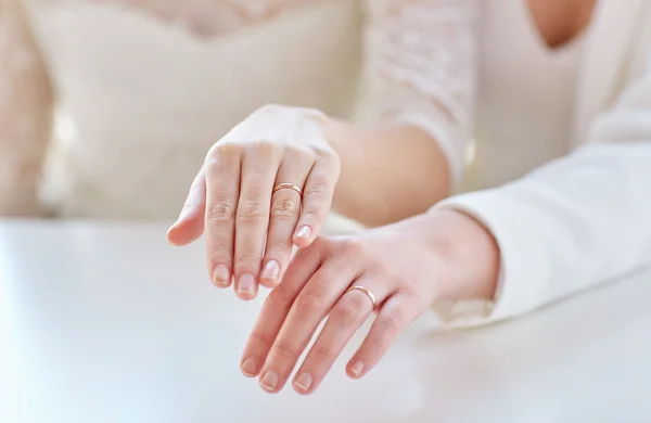 Close up de lésbicas casal mãos e alianças de casamento — Fotografia de Stock