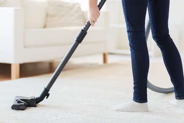 Закрыть ноги женщины с помощью вакуумной чистки дома — стоковое фото