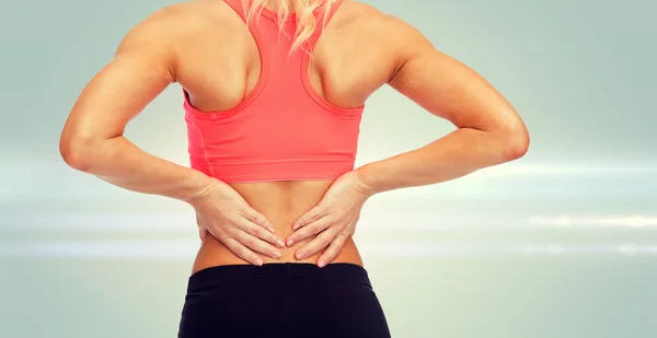 Close up of sporty woman touching her back Stock Photo