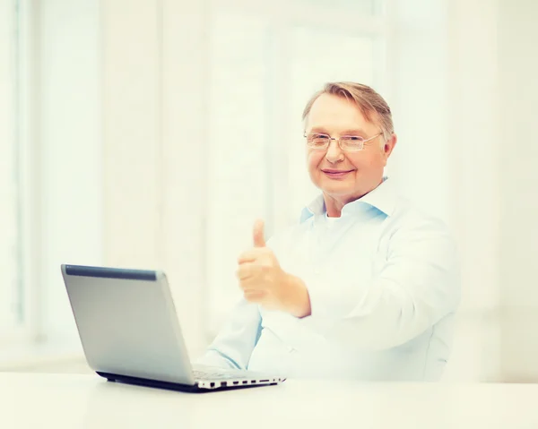 Viejo con computadora portátil mostrando los pulgares hacia arriba — Foto de Stock