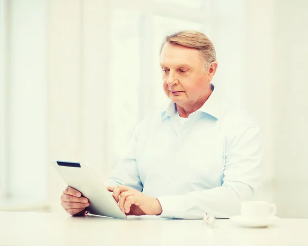 Vieil homme avec tablette PC à la maison — Photo