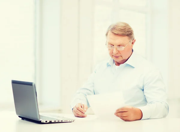 Oude man in brillen invullen van een formulier thuis — Stockfoto